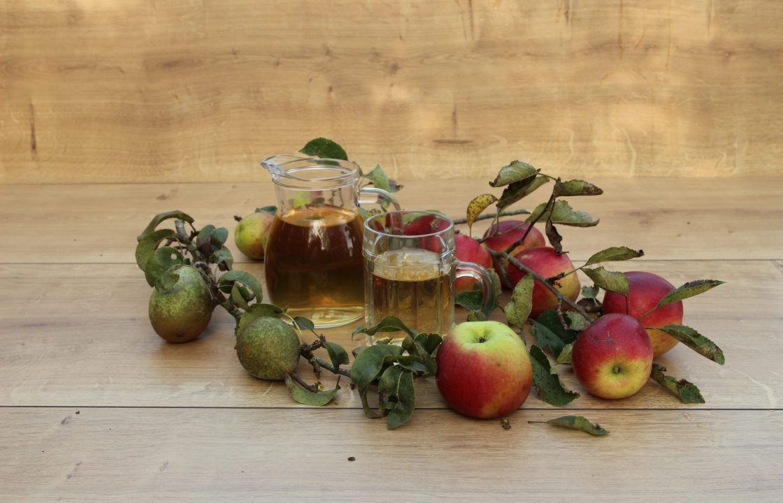 Äpfel und Mostbirne mit einem Krug Most